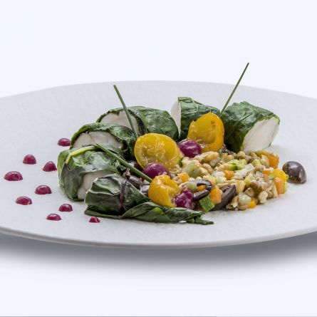 Monkfish wrapped in a veil of steamed chard served on a bed of mixed vegetable salad, cereals and Taggiasca olives