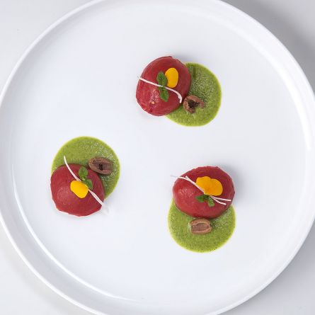 Cupole di pomodoro fresco semi-secco ripiene di ricotta e olive taggiasche su passata di zucchina alla mentuccia